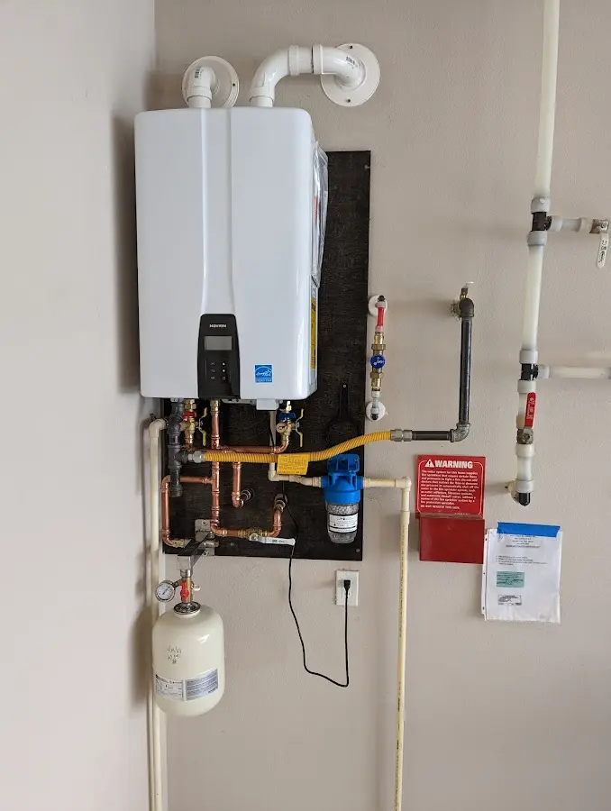 Professional plumber installing copper piping in a Canaan home